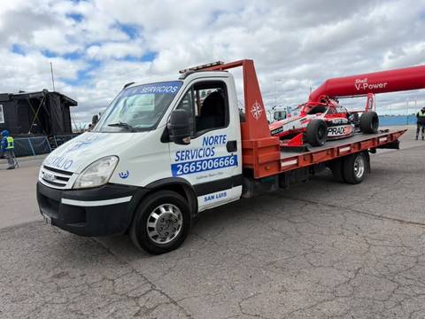 Auto monoplaza de competición cargado en una grúa de la flota, en un autódromo
