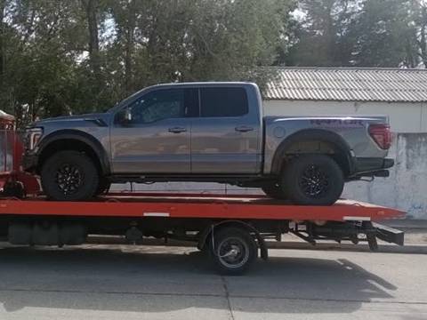 Camioneta pickup gris sobre la plataforma de una grúa